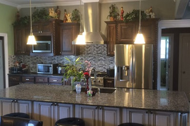 Large transitional u-shaped ceramic tile eat-in kitchen photo in Oklahoma City with an undermount sink, raised-panel cabinets, dark wood cabinets, granite countertops, multicolored backsplash, matchstick tile backsplash, stainless steel appliances and an island