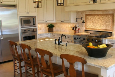 Example of a mid-sized classic u-shaped ceramic tile and beige floor eat-in kitchen design in San Diego with a farmhouse sink, recessed-panel cabinets, distressed cabinets, granite countertops, beige backsplash, ceramic backsplash, stainless steel appliances and an island