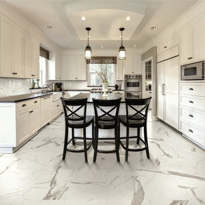 Inspiration for a large transitional u-shaped marble floor eat-in kitchen remodel in New York with a farmhouse sink, shaker cabinets, white cabinets, soapstone countertops, white backsplash, porcelain backsplash, stainless steel appliances and an island