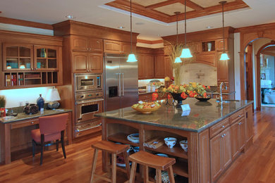 Example of a large classic u-shaped medium tone wood floor and brown floor open concept kitchen design in Tampa with beaded inset cabinets, medium tone wood cabinets, granite countertops, beige backsplash, ceramic backsplash, stainless steel appliances, an island and an undermount sink