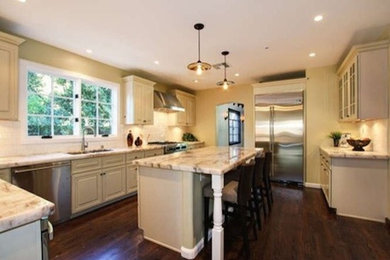 サクラメントにある広いトラディショナルスタイルのおしゃれなキッチン (白いキャビネット、シルバーの調理設備、濃色無垢フローリング) の写真