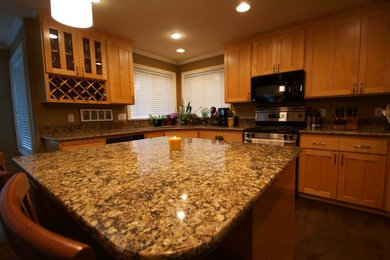 Elegant dark wood floor kitchen photo in Seattle with medium tone wood cabinets, granite countertops, brown backsplash, stainless steel appliances and an island