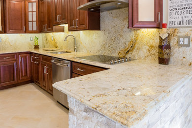 Inspiration for a large transitional galley ceramic tile and beige floor eat-in kitchen remodel in Philadelphia with an undermount sink, recessed-panel cabinets, dark wood cabinets, granite countertops, multicolored backsplash, stone slab backsplash, stainless steel appliances and a peninsula
