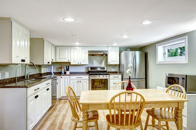 Example of a mid-sized classic l-shaped vinyl floor and multicolored floor eat-in kitchen design in Providence with an undermount sink, raised-panel cabinets, white cabinets, granite countertops, multicolored backsplash, stainless steel appliances, no island and multicolored countertops