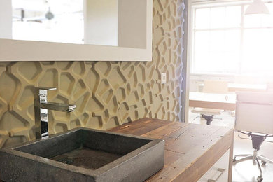 Modern inredning av ett mellanstort kök, med en enkel diskho, släta luckor, vita skåp, träbänkskiva, beige stänkskydd, betonggolv och beiget golv