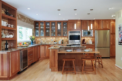 Kitchen - large traditional l-shaped light wood floor kitchen idea in Denver with an undermount sink, shaker cabinets, light wood cabinets, granite countertops, beige backsplash, stone tile backsplash, stainless steel appliances and an island
