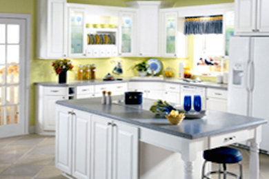 タンパにある中くらいなトラディショナルスタイルのおしゃれなキッチン (レイズドパネル扉のキャビネット、白いキャビネット、クオーツストーンカウンター、白い調理設備、セラミックタイルの床) の写真
