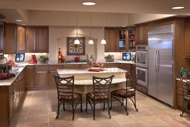 Mittelgroße Wohnküche in U-Form mit Doppelwaschbecken, hellbraunen Holzschränken, Granit-Arbeitsplatte, Küchengeräten aus Edelstahl, Keramikboden und Kücheninsel in Las Vegas