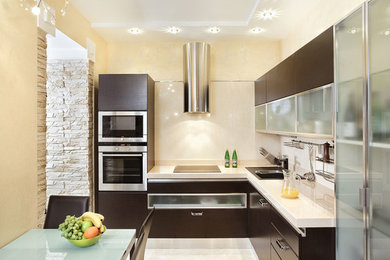 Example of a small trendy l-shaped ceramic tile and beige floor kitchen design in San Diego with flat-panel cabinets, dark wood cabinets, solid surface countertops and an island