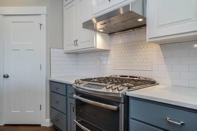 Large trendy u-shaped medium tone wood floor and brown floor kitchen photo in Salt Lake City with an undermount sink, white cabinets, quartz countertops, white backsplash, subway tile backsplash, stainless steel appliances, an island and raised-panel cabinets