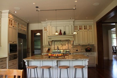 Arts and crafts l-shaped dark wood floor eat-in kitchen photo in Seattle with raised-panel cabinets, beige cabinets, granite countertops, beige backsplash, stainless steel appliances and an island