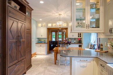 Example of a classic u-shaped ceramic tile eat-in kitchen design in Other with a farmhouse sink, recessed-panel cabinets, white cabinets, granite countertops, beige backsplash, stone tile backsplash, stainless steel appliances and a peninsula