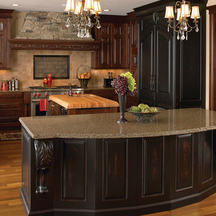 Design ideas for a large traditional u-shaped separate kitchen in Little Rock with an undermount sink, raised-panel cabinets, dark wood cabinets, granite benchtops, beige splashback, stone tile splashback, panelled appliances, medium hardwood floors, multiple islands and brown floor.
