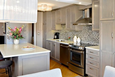 Example of a mid-sized transitional galley medium tone wood floor and brown floor open concept kitchen design in DC Metro with an undermount sink, shaker cabinets, beige cabinets, granite countertops, multicolored backsplash, matchstick tile backsplash, stainless steel appliances and an island