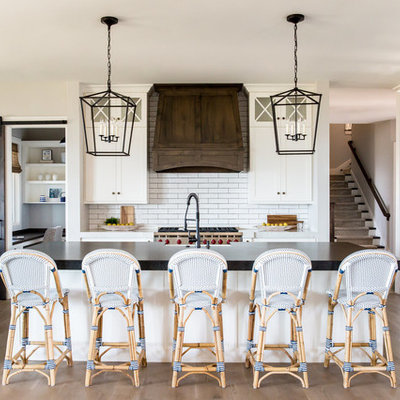 Inspiration for a country l-shaped medium tone wood floor and beige floor kitchen remodel in Phoenix with shaker cabinets, white cabinets, white backsplash, subway tile backsplash, stainless steel appliances and an island