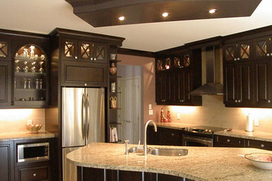 Inspiration for a large timeless l-shaped kitchen remodel in Toronto with dark wood cabinets, stainless steel appliances and an island