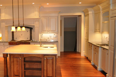 Example of a large trendy u-shaped dark wood floor eat-in kitchen design in Boston with a single-bowl sink, raised-panel cabinets, white cabinets, granite countertops, white backsplash and an island