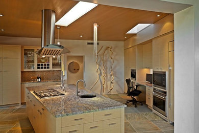 アルバカーキにある広いサンタフェスタイルのおしゃれなキッチン (シングルシンク、フラットパネル扉のキャビネット、淡色木目調キャビネット、茶色いキッチンパネル、シルバーの調理設備) の写真
