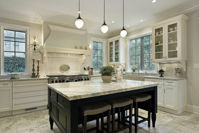 Eat-in kitchen - large contemporary l-shaped limestone floor and gray floor eat-in kitchen idea in New York with a farmhouse sink, recessed-panel cabinets, white cabinets, marble countertops, white backsplash, subway tile backsplash, stainless steel appliances and an island