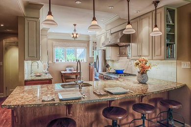 Example of a mid-sized l-shaped medium tone wood floor open concept kitchen design in Indianapolis with a farmhouse sink, raised-panel cabinets, white cabinets, granite countertops, white backsplash, subway tile backsplash, stainless steel appliances and a peninsula
