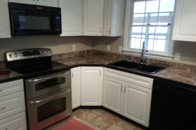 ワシントンD.C.にある中くらいなトランジショナルスタイルのおしゃれなキッチン (ダブルシンク、レイズドパネル扉のキャビネット、白いキャビネット、シルバーの調理設備) の写真