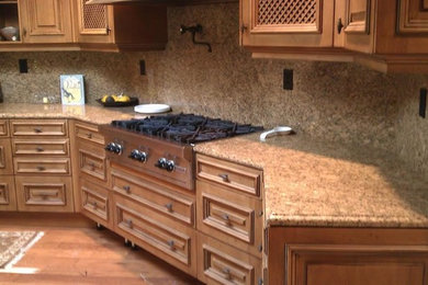 Mittelgroße Klassische Küche mit profilierten Schrankfronten, hellbraunen Holzschränken, Granit-Arbeitsplatte, Küchenrückwand in Braun, Rückwand aus Stein, Küchengeräten aus Edelstahl, braunem Holzboden und braunem Boden in San Francisco