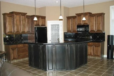 Mid-sized l-shaped ceramic tile open concept kitchen photo in Calgary with beaded inset cabinets, dark wood cabinets, onyx countertops, black backsplash, ceramic backsplash, black appliances and an island
