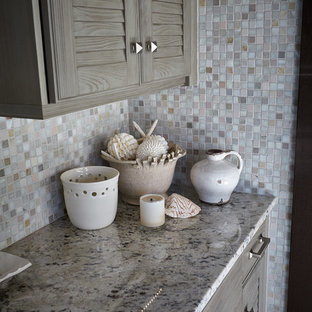 Photo of a traditional l-shaped eat-in kitchen in Other with a farmhouse sink, louvered cabinets, distressed cabinets, granite benchtops, multi-coloured splashback, mosaic tile splashback and stainless steel appliances.