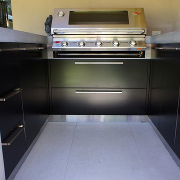 Outdoor Kitchen | polished concrete worktops, black cabinets and dark timber