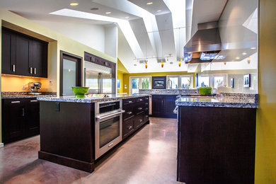 Große Klassische Küche mit Unterbauwaschbecken, Schrankfronten im Shaker-Stil, dunklen Holzschränken, Granit-Arbeitsplatte, Küchenrückwand in Weiß, Glasrückwand, Küchengeräten aus Edelstahl, Betonboden und Kücheninsel in Vancouver