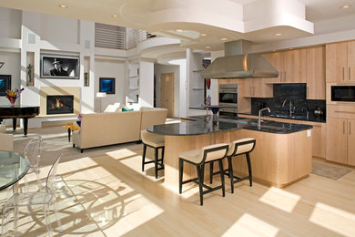 Example of a trendy single-wall light wood floor eat-in kitchen design in Minneapolis with an undermount sink, flat-panel cabinets, black backsplash, stone slab backsplash and an island