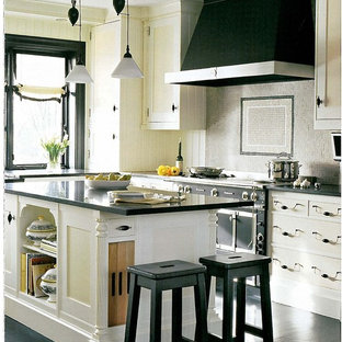 Idee per una cucina design con paraspruzzi con piastrelle a mosaico, ante gialle, ante con riquadro incassato e elettrodomestici neri