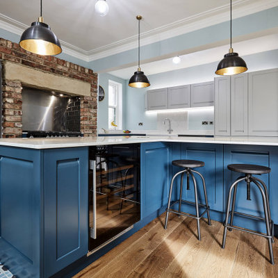 Inspiration for a large transitional l-shaped porcelain tile, blue floor and coffered ceiling eat-in kitchen remodel in Other with a farmhouse sink, shaker cabinets, blue cabinets, marble countertops, white backsplash, marble backsplash, stainless steel appliances, two islands and white countertops