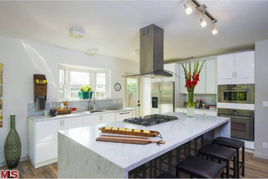 Example of a transitional l-shaped kitchen design in Los Angeles with an island