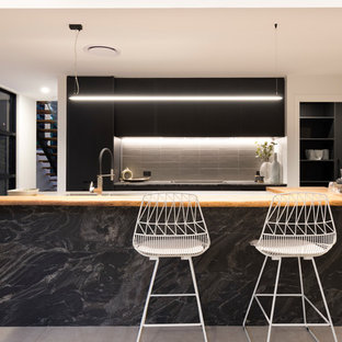 Inspiration for a contemporary galley kitchen in Brisbane with flat-panel cabinets, black cabinets, black splashback and with island.