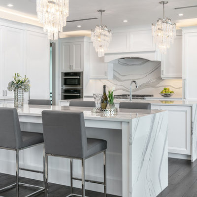 Inspiration for a contemporary l-shaped medium tone wood floor and gray floor eat-in kitchen remodel in Tampa with recessed-panel cabinets, white cabinets, white backsplash, stainless steel appliances, an island and white countertops