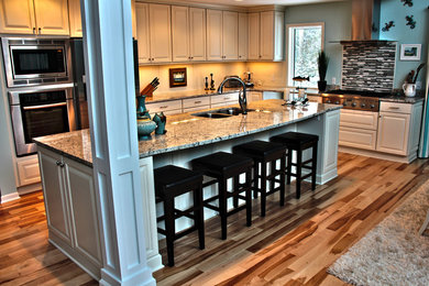 Eat-in kitchen - traditional l-shaped eat-in kitchen idea in Other with a drop-in sink, granite countertops, multicolored backsplash and stainless steel appliances