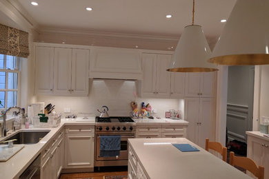 サンフランシスコにある高級な中くらいなコンテンポラリースタイルのおしゃれなキッチン (アンダーカウンターシンク、シェーカースタイル扉のキャビネット、白いキャビネット、珪岩カウンター、白いキッチンパネル、セラミックタイルのキッチンパネル、シルバーの調理設備、淡色無垢フローリング) の写真