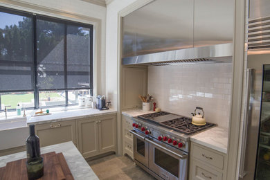 Example of a large minimalist u-shaped porcelain tile and gray floor enclosed kitchen design in San Francisco with a farmhouse sink, shaker cabinets, gray cabinets, soapstone countertops, white backsplash, subway tile backsplash, stainless steel appliances and an island