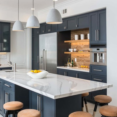 Example of a transitional gray floor kitchen design in Los Angeles with an undermount sink, shaker cabinets, black cabinets, an island, white countertops and brown backsplash