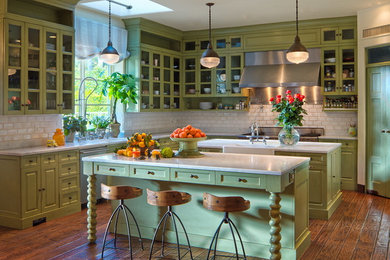 Inspiration for a mediterranean medium tone wood floor kitchen remodel in Los Angeles with green cabinets, marble countertops, white backsplash, stone tile backsplash, stainless steel appliances and two islands