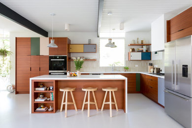 Inspiration for a mid-century modern l-shaped gray floor kitchen remodel in Los Angeles with an undermount sink, flat-panel cabinets, dark wood cabinets, beige backsplash, stainless steel appliances and an island