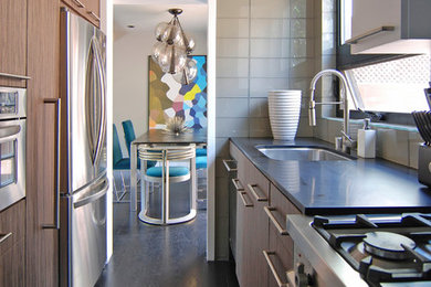 Example of a small trendy galley dark wood floor enclosed kitchen design in Los Angeles with an undermount sink, flat-panel cabinets, medium tone wood cabinets, quartz countertops, gray backsplash, glass tile backsplash, stainless steel appliances and no island