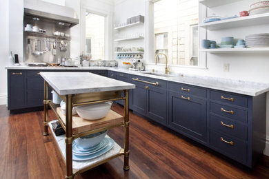Enclosed kitchen - mid-sized traditional l-shaped medium tone wood floor enclosed kitchen idea in San Francisco with a single-bowl sink, shaker cabinets, blue cabinets, marble countertops, white backsplash, stone slab backsplash, paneled appliances and an island