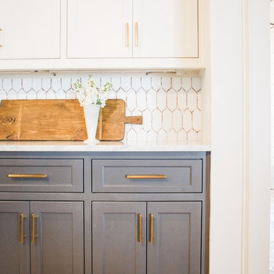 Open concept kitchen - large traditional l-shaped medium tone wood floor and brown floor open concept kitchen idea in Houston with recessed-panel cabinets, gray cabinets, marble countertops, white backsplash, ceramic backsplash, an island and white countertops
