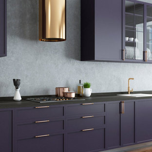 Inspiration for a large contemporary single-wall eat-in kitchen in Columbus with a drop-in sink, recessed-panel cabinets, blue cabinets, quartz benchtops, grey splashback, stainless steel appliances, medium hardwood floors, with island, brown floor and black benchtop.