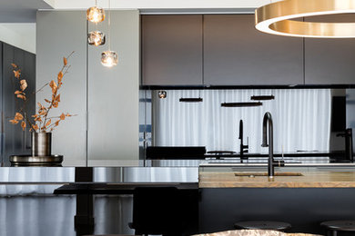 This is an example of a contemporary kitchen in Auckland with metallic splashback and glass sheet splashback.