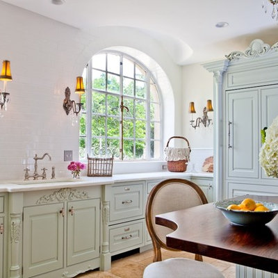 Mid-sized cottage chic u-shaped ceramic tile enclosed kitchen photo in St Louis with wood countertops, green cabinets, an undermount sink, raised-panel cabinets, white backsplash, subway tile backsplash and paneled appliances