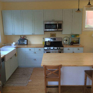 Idee per una piccola cucina country con lavello stile country, ante in stile shaker, ante turchesi, top in legno, elettrodomestici in acciaio inossidabile, pavimento in bambù, isola e pavimento marrone