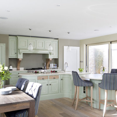Example of a classic eat-in kitchen design in Dublin with recessed-panel cabinets, green cabinets and stainless steel appliances